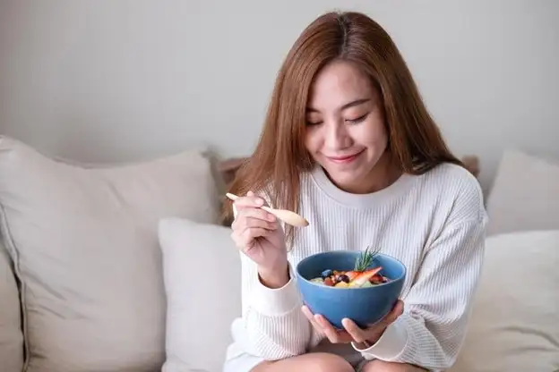 Girl eating with a food bowl