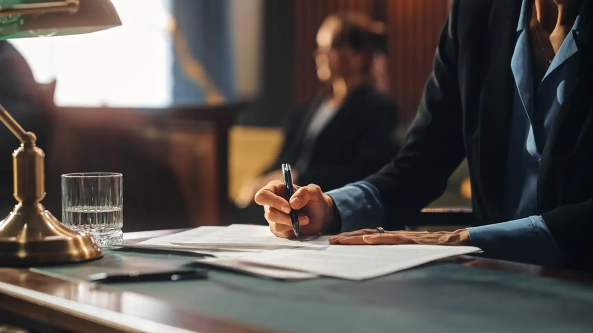 man signing a document in a meeting room