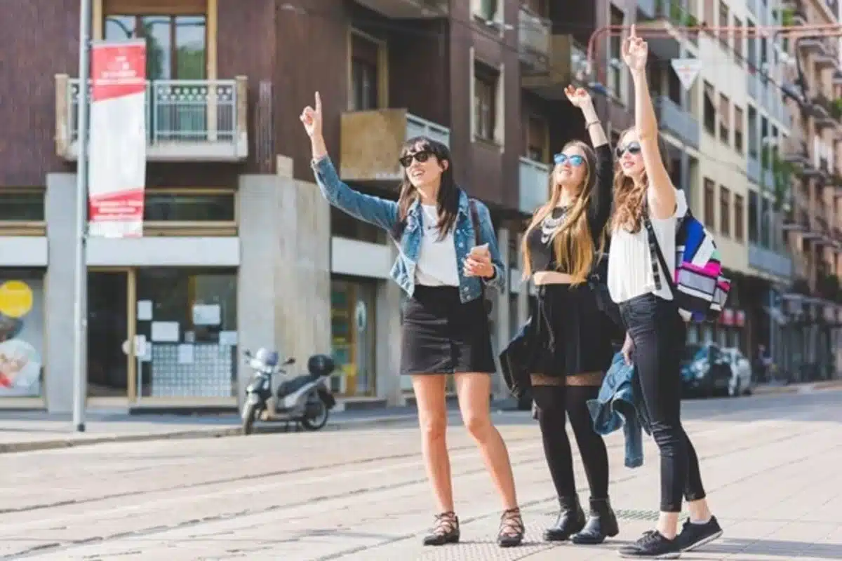 three girls hailing a cab in the city