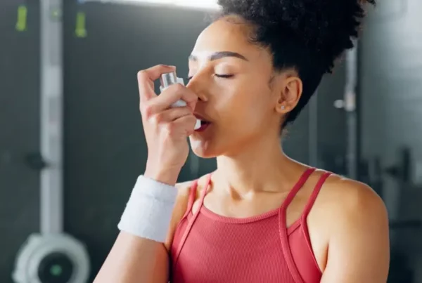 Asthma inhaler breathe at gym with fitness coach for chest relief and wellness